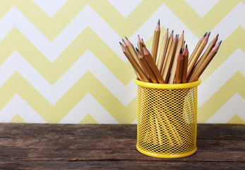 Pencils in metal holder on the table, closeup