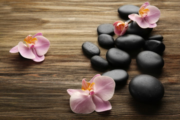 Obraz na płótnie Canvas Spa stones and orchid flowers on wooden background