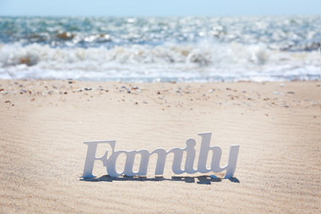 Word family on a sand, close up