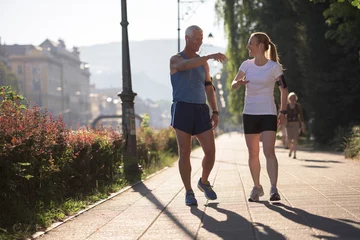 Photo sur Aluminium Jogging couple de jogging planifiant un itinéraire de course et mettant de la musique