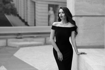 Black and white portrait of young beautiful elegant woman in black dress. Pretty sensual girl with...