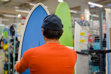 Male with a surf board on indoors background 