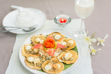 Baked scallops with butter and soy sauce in natural scallop shell delicious Thai seafood.