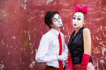 Obraz premium Couple mimes cute pose in front of a red wall.