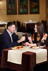 Couple toasting wineglasses in a luxury restaurant