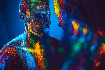 People are colored fluorescent powder. a pair of lovers dancing