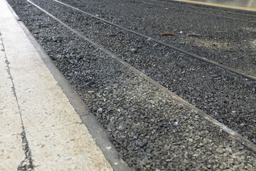Obraz premium Oblique view of railway and footpath in train station.