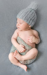 sleeping newborn baby in grey hat with little blanket, top view © tan4ikk