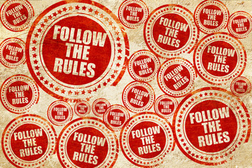 follow the rules, red stamp on a grunge paper texture