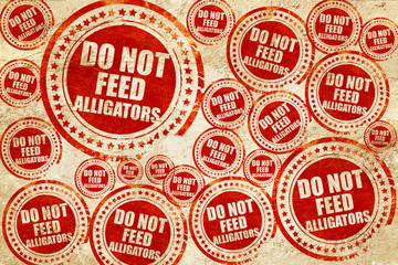 Fototapeta premium do not feed alligators, red stamp on a grunge paper texture