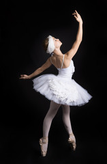 Naklejka premium Ballerina is dancing on a black background