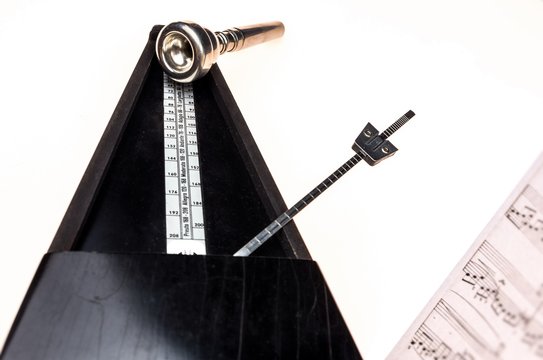Metronome and mouthpiece of a trumpet isolated on a blank white