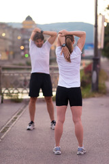 couple warming up before jogging