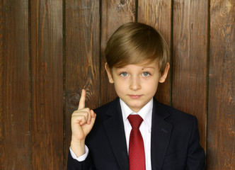 cute boy in suit and tie on a wooden background © Olga Kriger