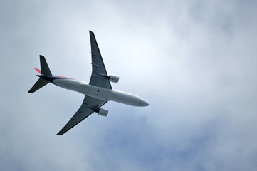 Fototapeta na wymiar Пассажирский самолет на фоне пасмурного облачного неба 