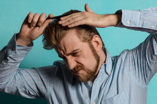 Young Blond Man In Striped Shirt Comb His Hair