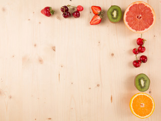 Flat lay of orange,kiwi, cherry, strawberry on wooden background