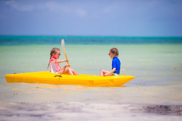 Little adorable girls enjoying kayaking in the sea