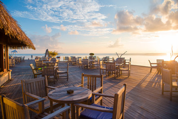 Summer empty open air restaraunt near sea at exotic island on beautiful sunset