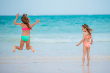 Naklejka premium Little girls playing together at shallow water on vacation