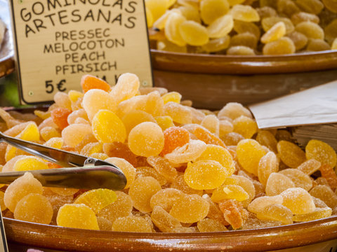 Traditional sweets (gominolas artesanas) made out of dried peach with sugar for sale on a market stand at Majorca,Spain, Europe - close-up