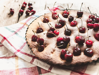 Creme brownie cake with cherry on a wooden board