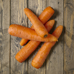 A pile of carrots on a wooden background