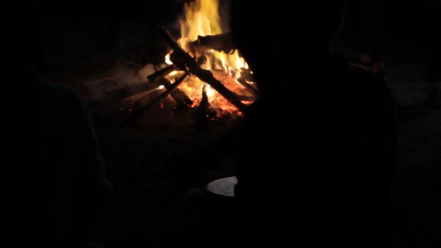performance of a ritual dance around a bonfire to the sounds of a shaman drum
