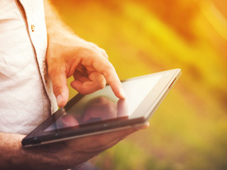 Man with digital tablet outdoors, close up