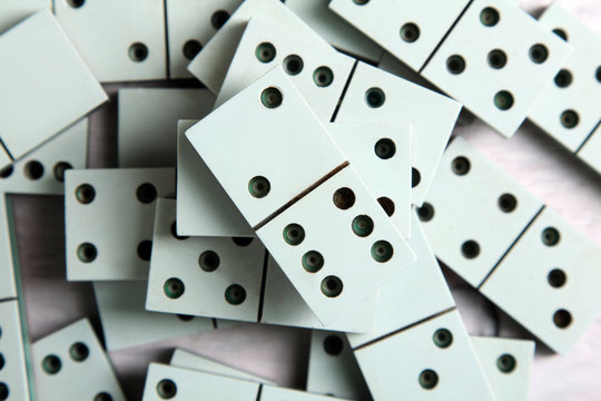 a bunch of dominoes lying on a white wooden background