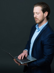 geschäftsmann schaut im stehen auf laptop