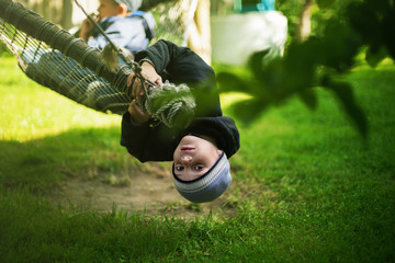 kid hanging hammock upside down backyard background selective focus