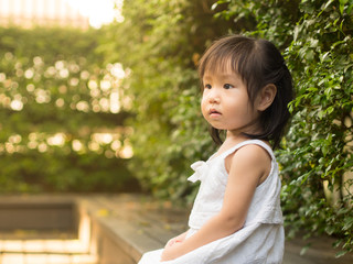 little asian girl sit in the garden in sunset light