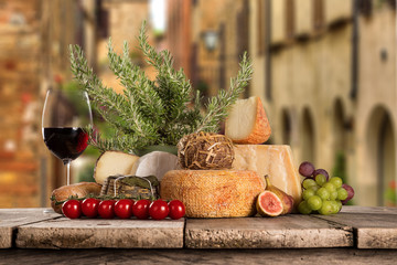 Delicious cheeses with wine on old wooden table.