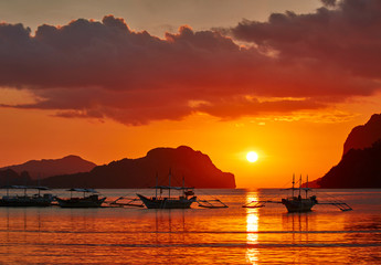 Traditional filippino boats at El Nido bay in sunset lights.