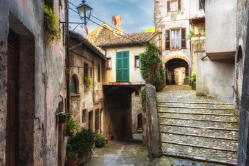 Fototapeta na wymiar Spring streets of the old Tuscan town. Colorful flowers bloom 