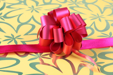 Bow on ribbon on color background