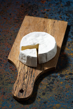 Camembert cheese on a cutting board, top view