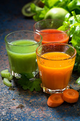 glasses of fresh vegetable juice from carrots, tomatoes and herb