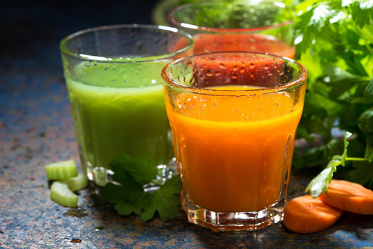glasses of fresh vegetable juice from carrots, tomatoes and herb