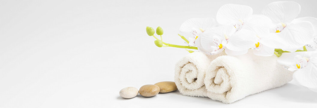 Spa orchid with soft towels and massage stones setting