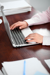 Close up of business woman hands typing on laptop computer