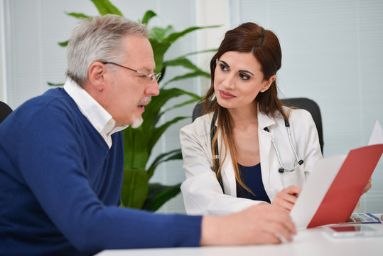 Doctor speaking to her patient while showing some documents