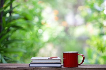 Red mug and notebooks with flower