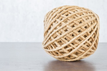 Hemp ball on wooden table with copyspace with selective focus.