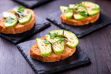 Toast with avocado, herbs on slate board