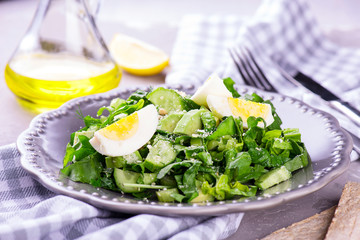 spinach and avocado salad on grey plate