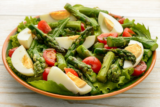 Appetizer - delicious salad with green asparagus, tomatoes and eggs