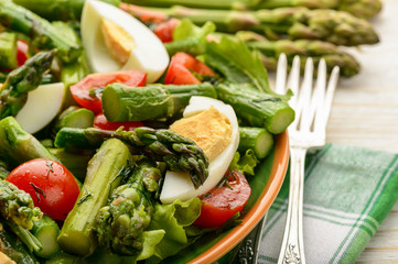 Appetizer - delicious salad with green asparagus, tomatoes and eggs