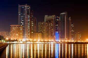 Obraz na płótnie Canvas Night cityscape of Sharhaj with reflection in the gulf, UAE